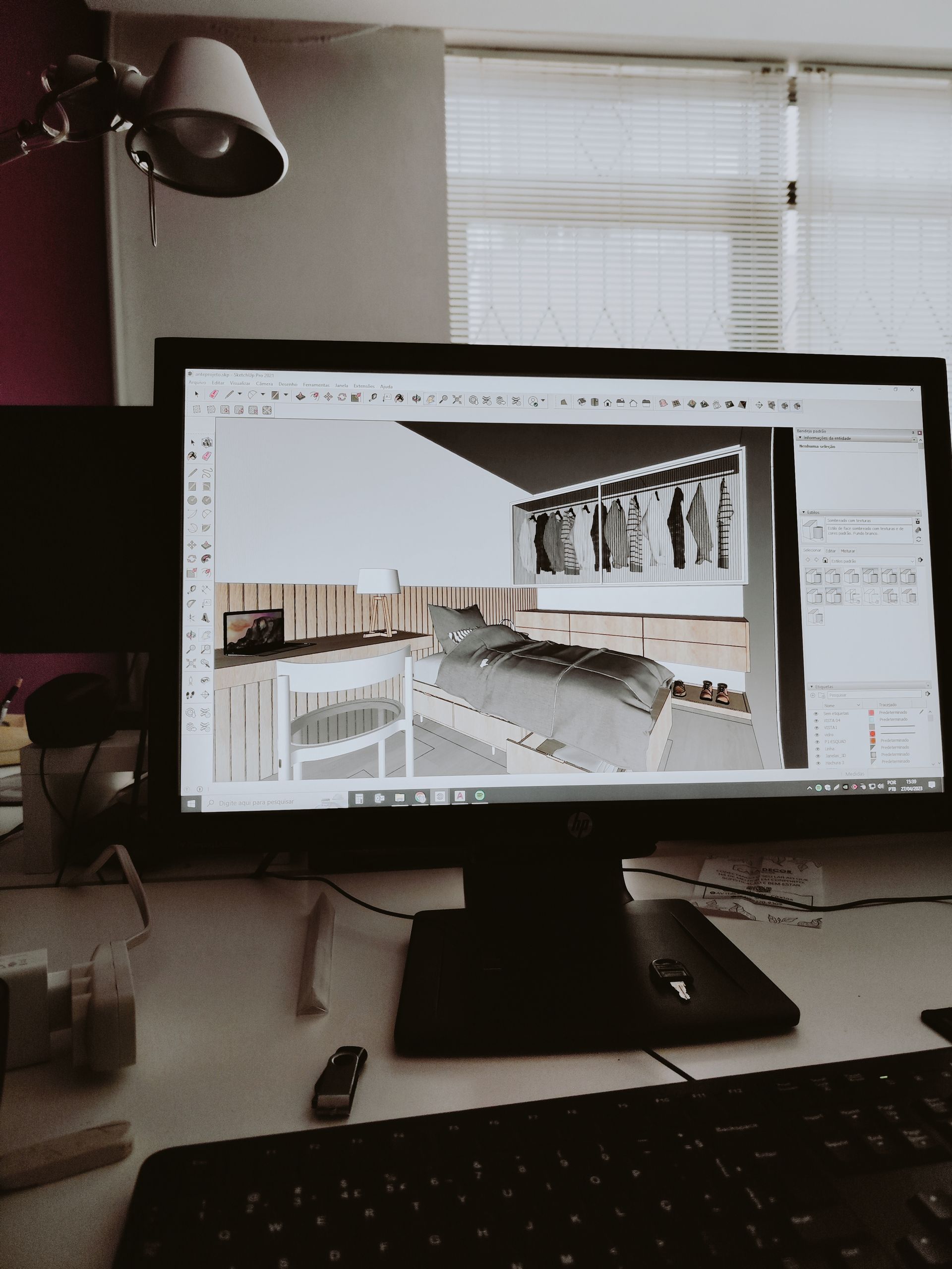 A desktop monitor displaying a 3D room design in a contemporary office setting.
