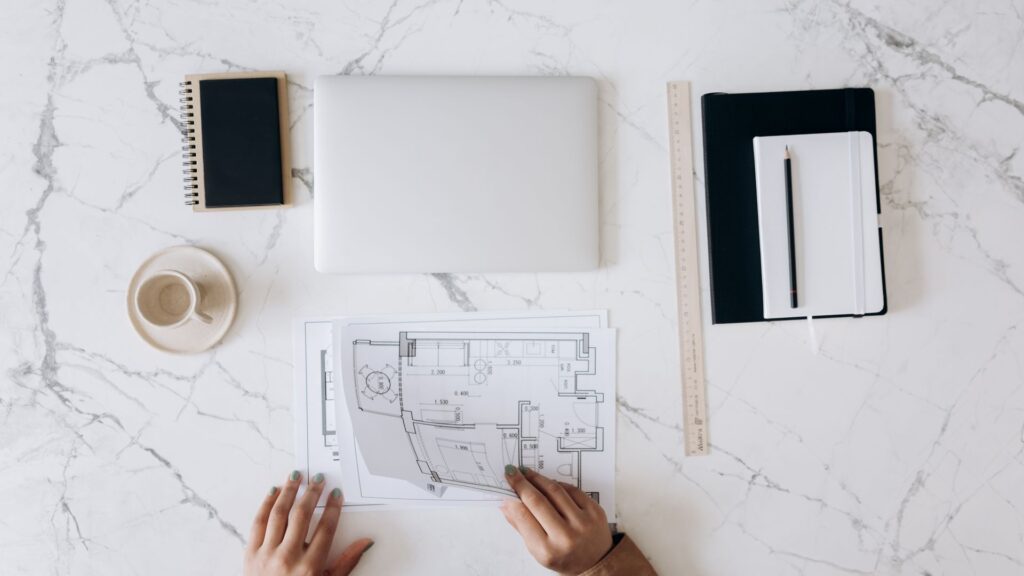 Architect's work table with blueprints, laptop, and drafting tools