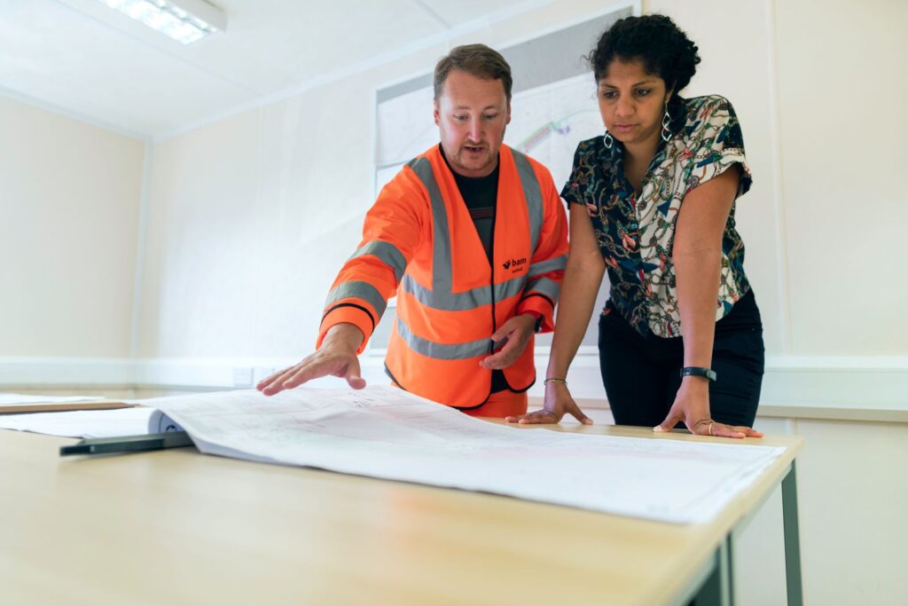 Engineers reviewing a blueprint together at a worktable