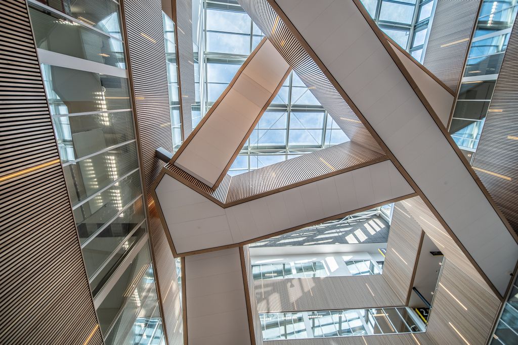 Dynamic architectural design featuring glass ceilings and intricate staircases.