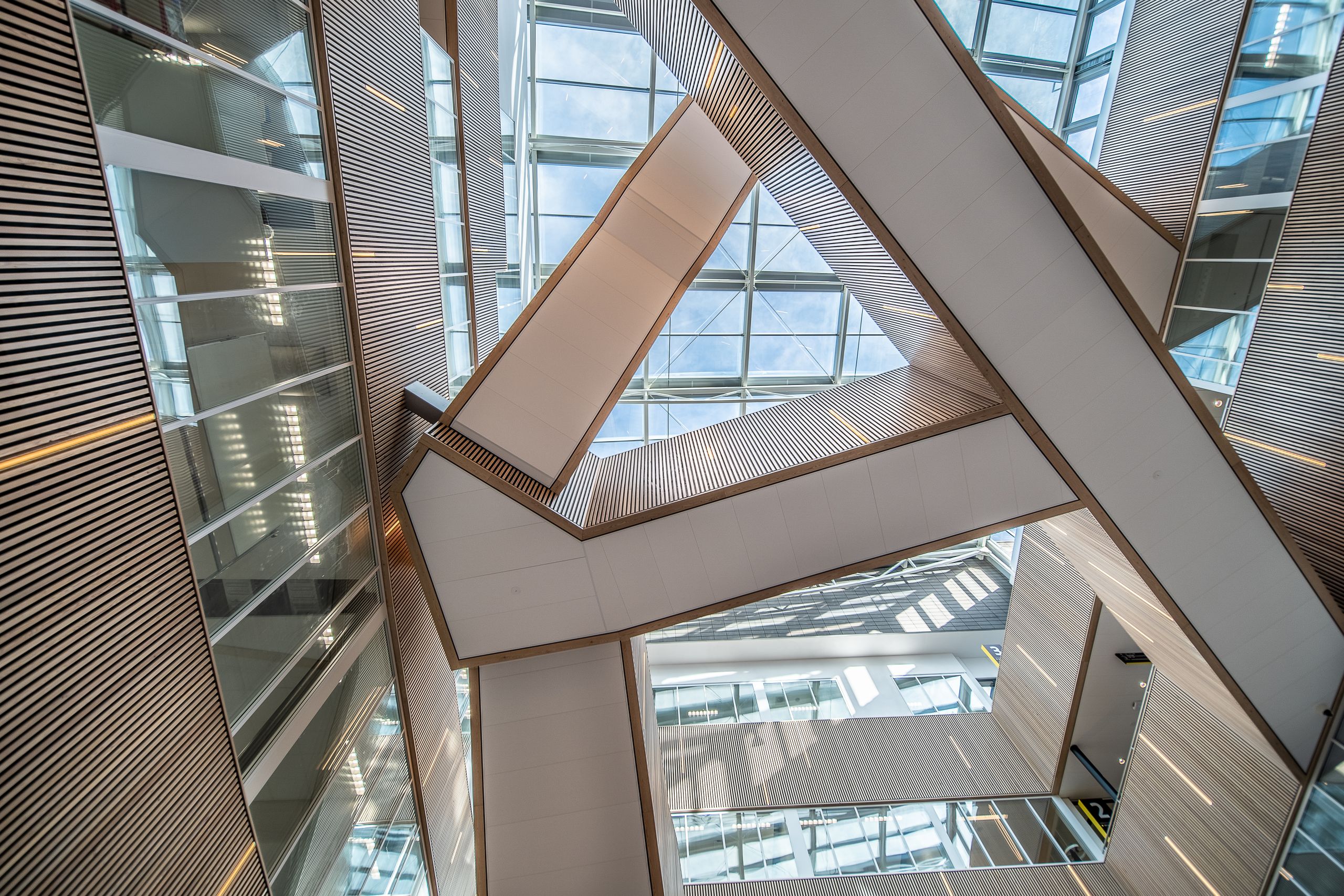Dynamic architectural design featuring glass ceilings and intricate staircases.