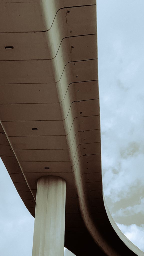 Perspective view of a modern concrete overpass with clear sky background.