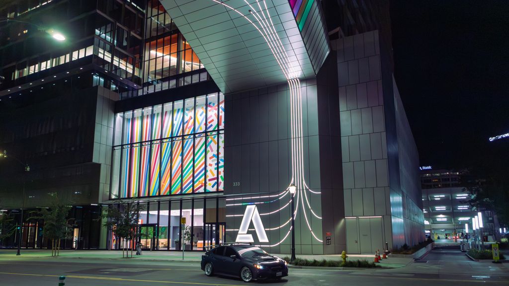 Vibrant city scene at night featuring modern architecture and colorful lights.