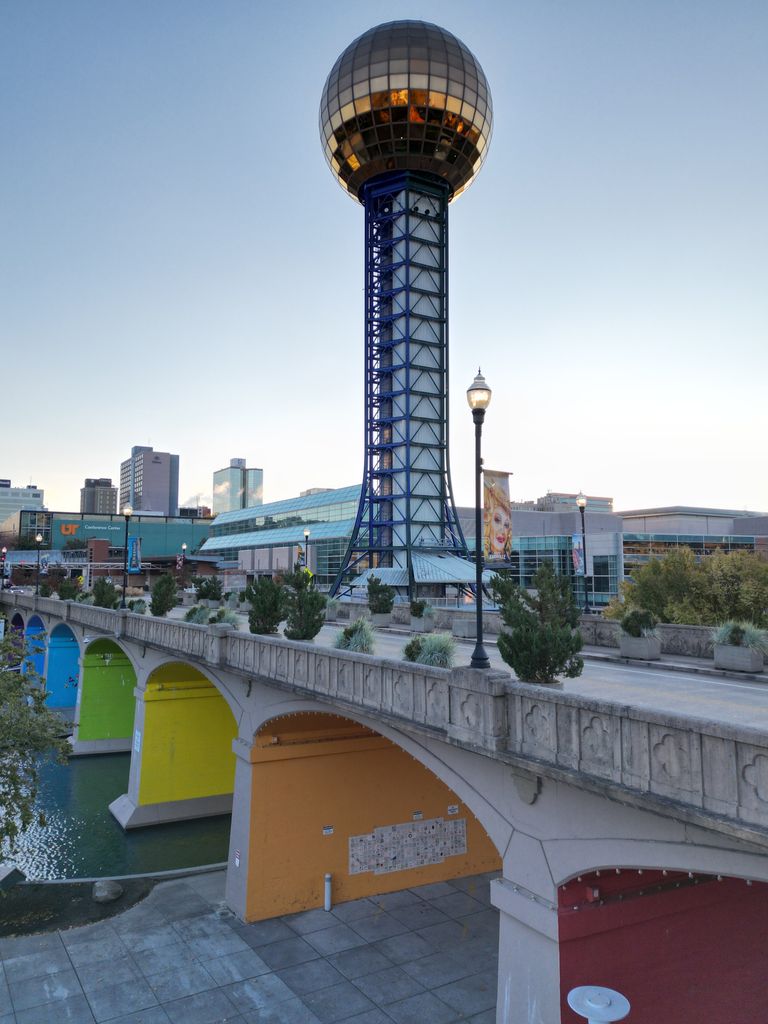 Iconic Sunsphere tower from World's Fair Park in Knoxville, TN, with colorful bridge and skyline.