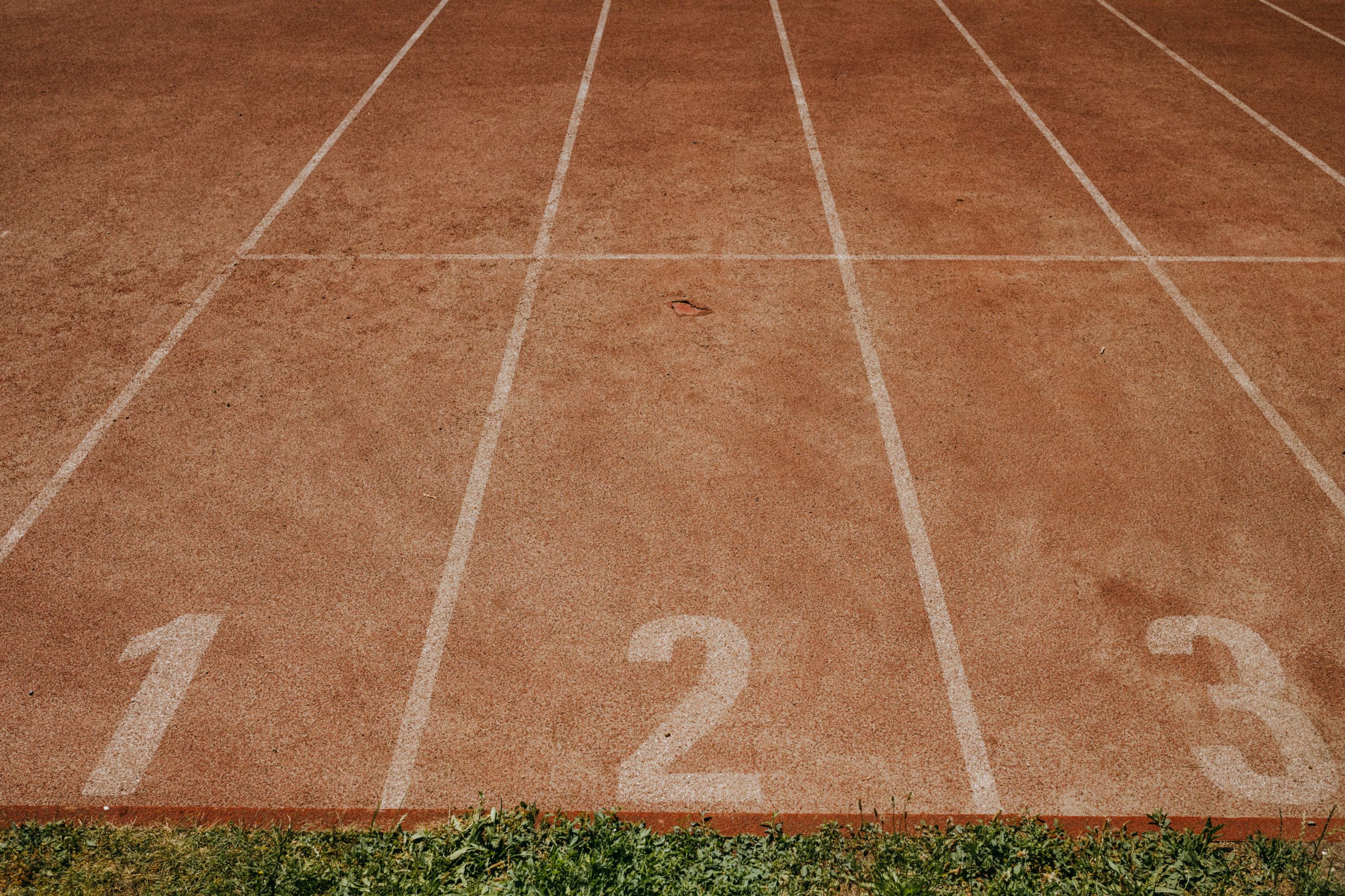 Outdoor sports track with lanes numbered 1 to 3, ready for an athletic event.
